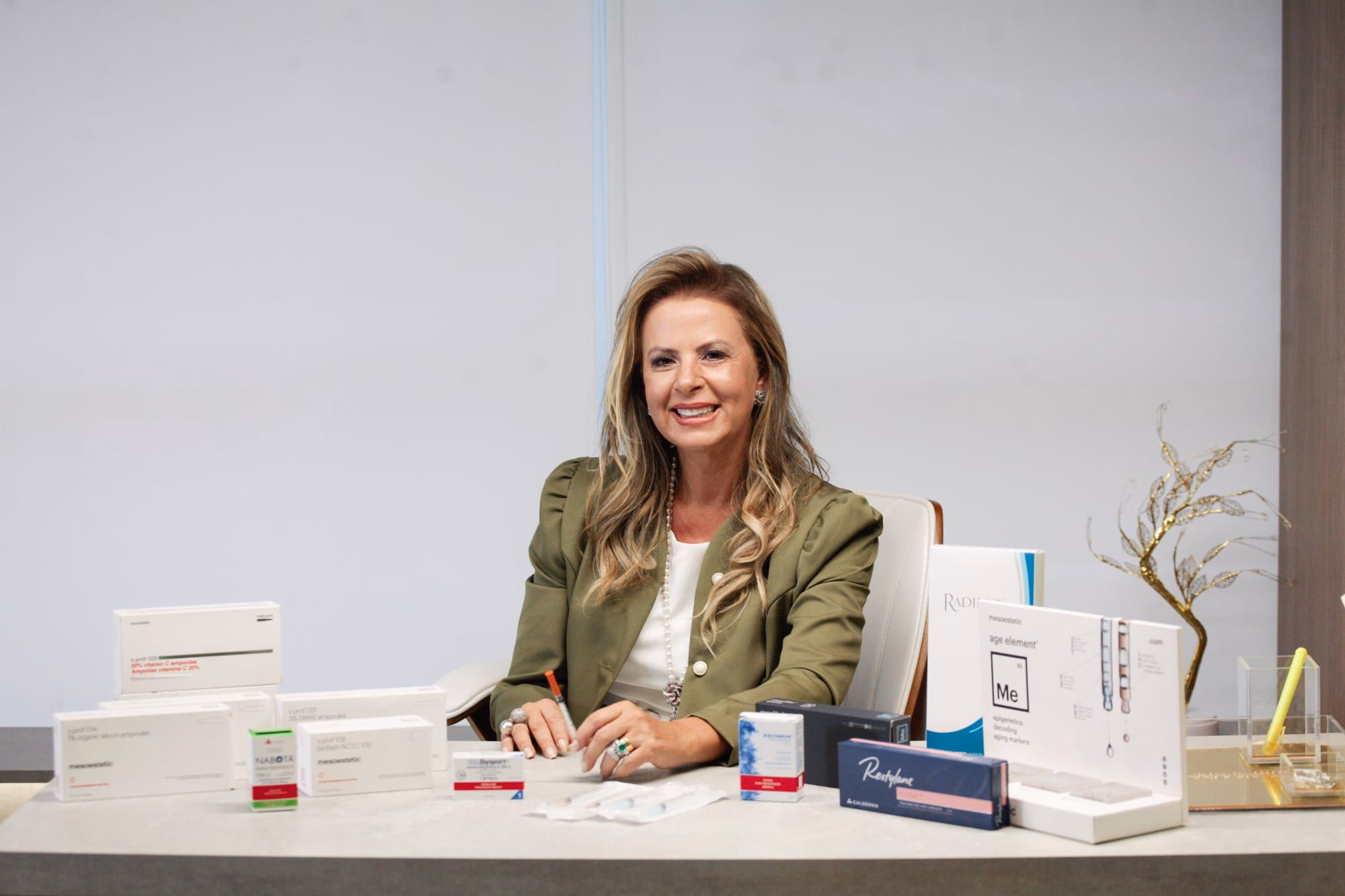 Dra. Carolina Resende, biomédica especializada em estética regenerativa, sorrindo em seu consultório com produtos profissionais Mesoestetic