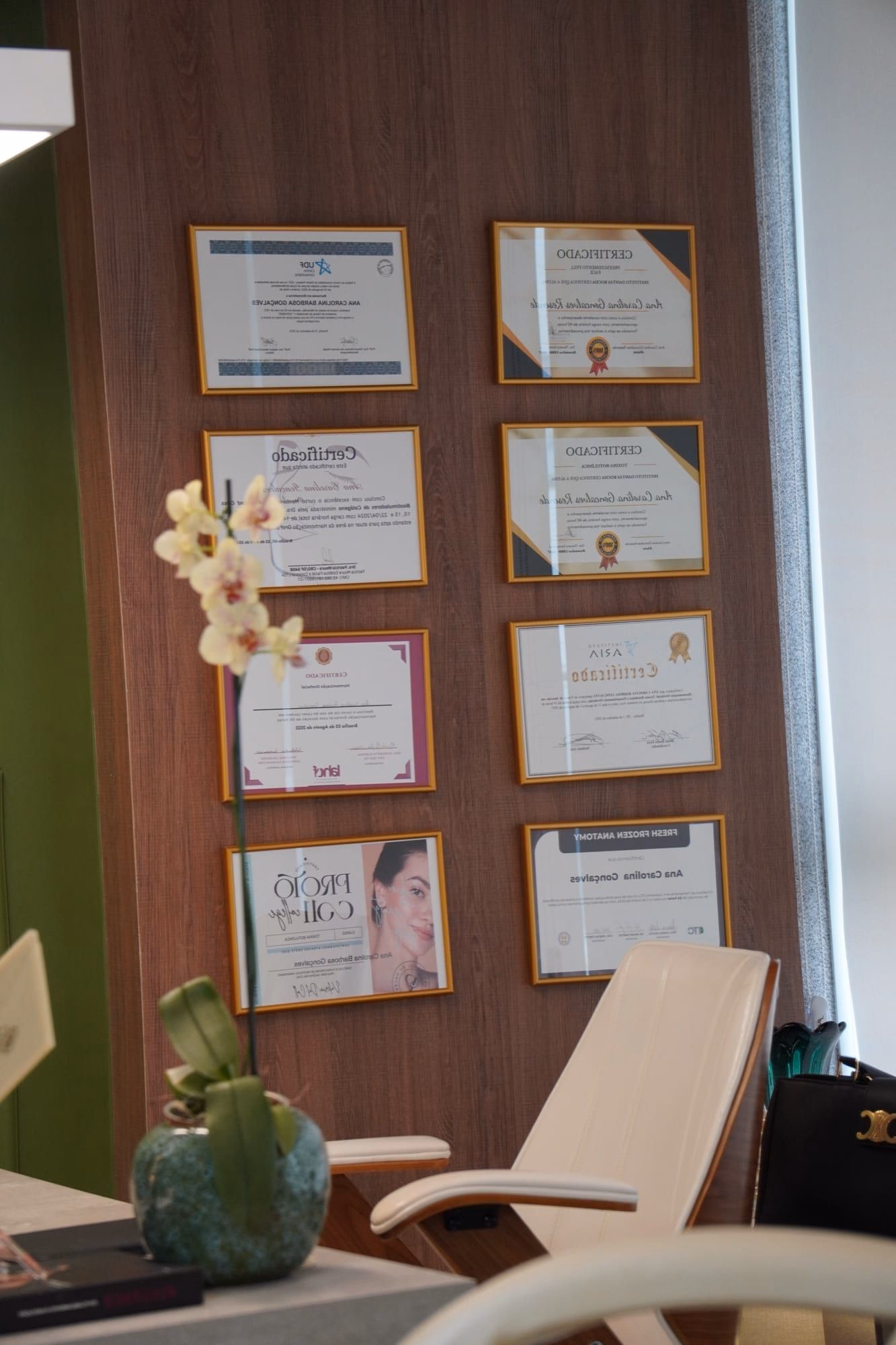 Parede com mais de quinze certificações da Dra. Carolina Resende em estética avançada e regenerativa